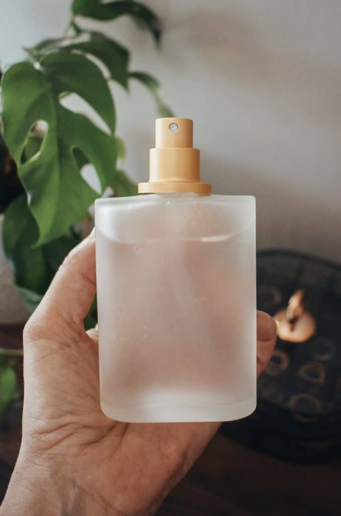 A person holding homemade hair growth spray.