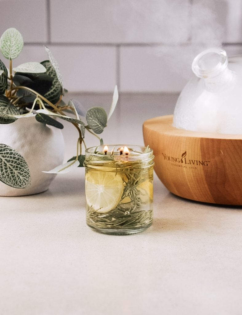 A homemade floating candle sits on the counter next to a plant and an essential oil diffuser.