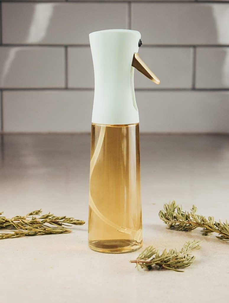 A spray bottle filled with rosemary water sits on the kitchen counter.