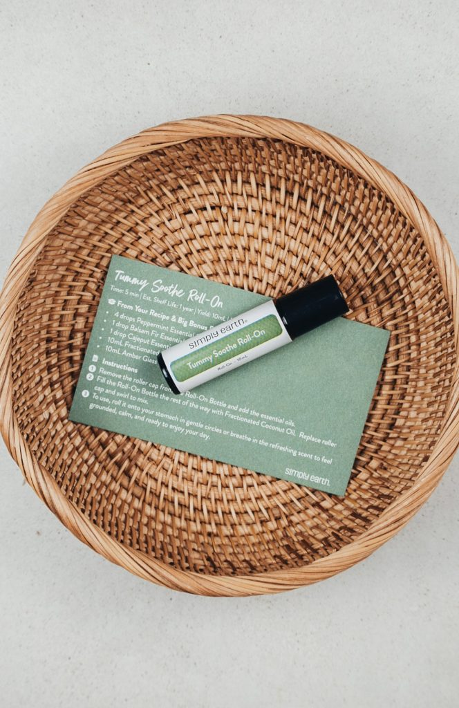 Homemade essential oil roller in a rattan basket on the counter.