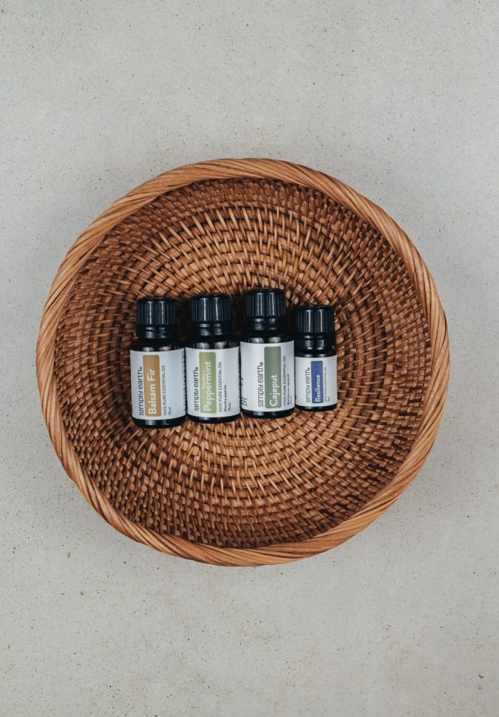 Essential oils from the Simply Earth September 2025 box in a rattan basket.
