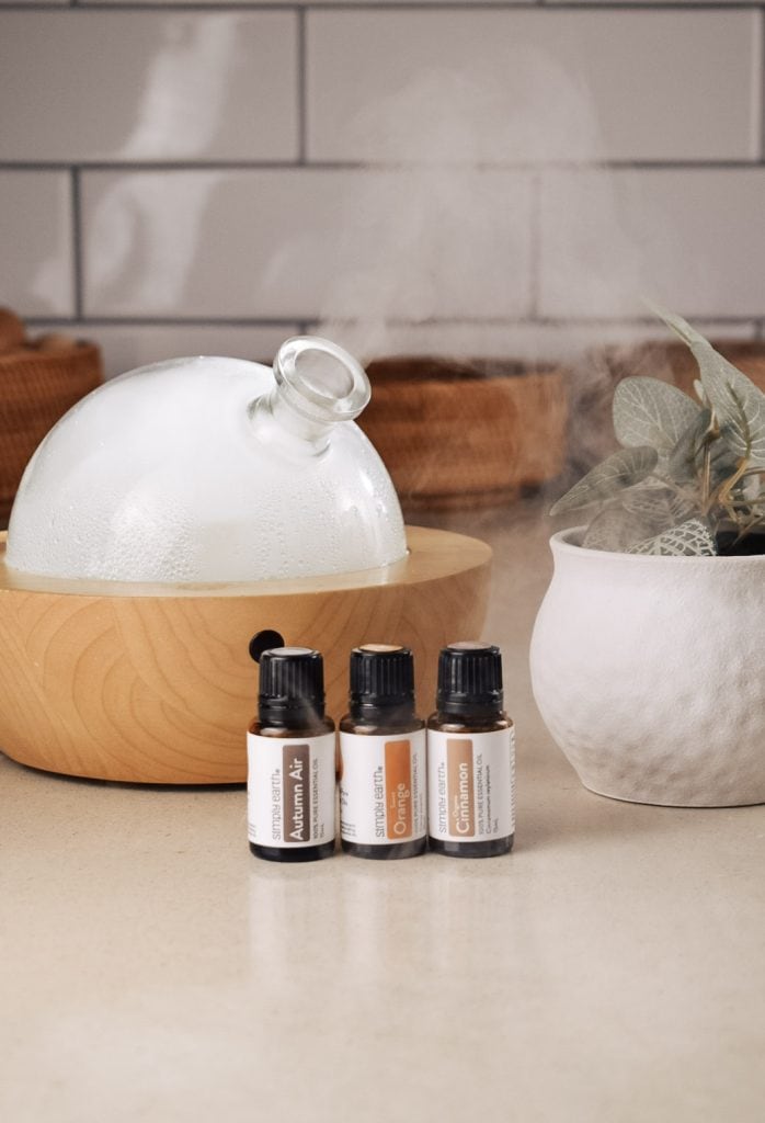 Essential oils next to an essential oil diffuser.